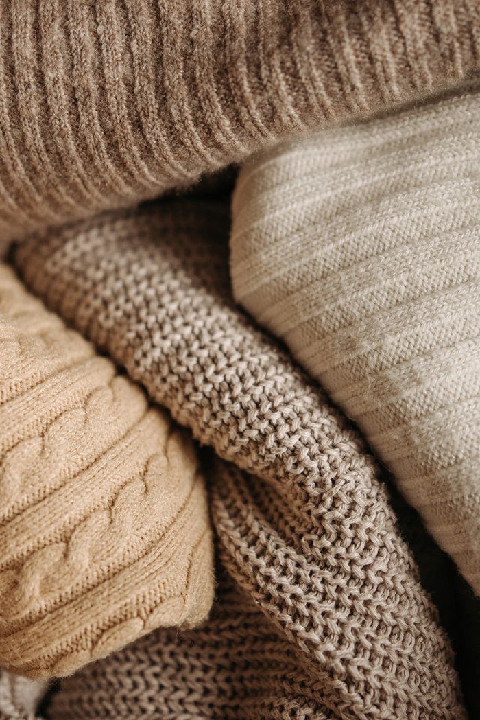 A detailed close-up of assorted knitted textiles showcasing different patterns and textures.