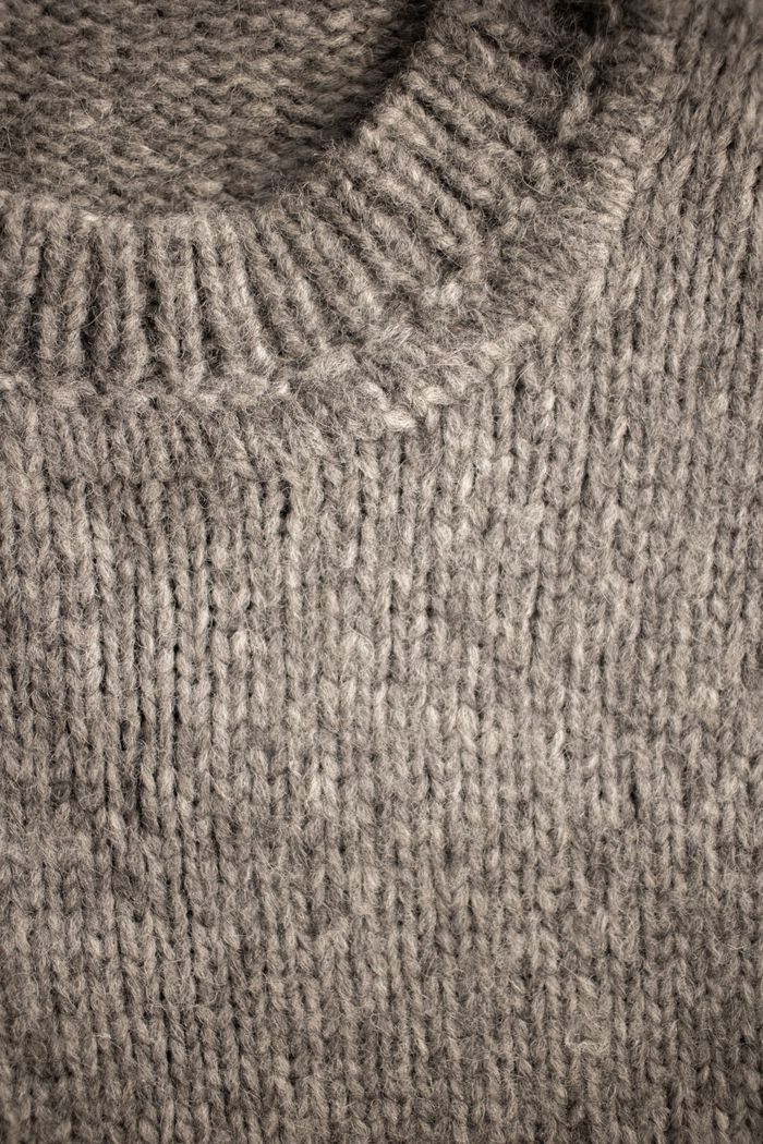 contact-img From above of collar of light beige knitted sweater with soft uneven texture